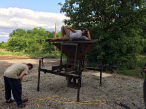 Intern Jason Shah lies on top of completed CEB Press as Mike Penpergast puts away equipment.