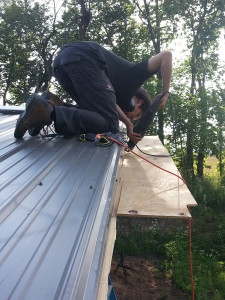 Guillaume Coudray works on installing the soffit from on top of the Hab Lab.